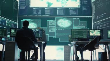 Hükümet hackerları bilgisayar sistemlerini siber tehditlerden koruyorlar. Teşkilat kontrol odasında birlikte çalışıyorlar. Şifreleme, çevrimiçi güvenlik ve siber saldırılara karşı casusluk. Kamera B.