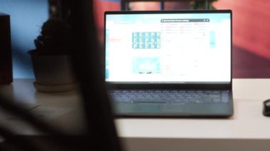 Finansal veri satış raporlarını gösteren bir dizüstü bilgisayarı olan boş bir ofis, uzaktan çalışan küçük bir işletme sahibinin kurulumu. Finans ve ekonomi bilgi grafikleri dengesi. Para yönetimi.