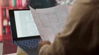 İşadamı evindeki iş yerindeki ticari ofis alanlarını araştırıyor, mükemmel bir başlangıç mülkü bulmak için planlar gözden geçiriyor ve bina planlarını hazırlıyor. Gayrimenkul. Kamera A.