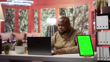 İşletme sahibi, yıllık satış analizleri ve raporları karını artırmak için kullanarak tabletteki bir modelleme sergisinin yanında mali planlar yönetiyor. Girişimci evde bütçe analizi yapıyor. Kamera B.