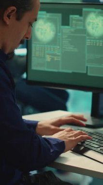 Vertical Video Hükümeti Bilişim Uzmanı bilgisayar ve büyük ekran, yüksek teknoloji ajansı ofisindeki siber tehditleri izliyor. Korsanlar tehlikeli dijital sistemlerin korunması için siber savunma önlemlerini inceliyor