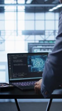 Sunucu merkezindeki dikey video mühendisi insan beyni simülasyonu yapan yapay zeka bilgisayarlı modelle çalışıyor. Dizüstü bilgisayarda çalışan bir adam AI makinesiyle kalıp tanıma kullanarak algoritma öğreniyor