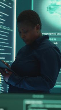 Siber olayları araştıran ve güvenlik tehditlerini büyük ekranda izleyen dikey video hükümet hackerı. Kadın uzmanlar önemli bilgileri çalmak için sahtekarlık teknikleri kullanırlar.