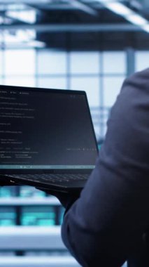 Veritabanı elektronik yaşam süresini uzatmak için laptopunu kullanarak yıllık bakım kontrolü yapan dikey video programcısı. Not defteri kullanarak sunucu tarım izleme sunucusu altyapısında bilişim uzmanı