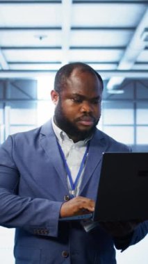 Veri merkezindeki dikey bilgisayar bilimcisi, hata nedenlerini tespit etmek için dizüstü bilgisayardaki tanısal araçları ve sistem izleme yazılımını kullanıyor. Sunucu tarım tesisi onarımı konusunda bilişim uzmanı