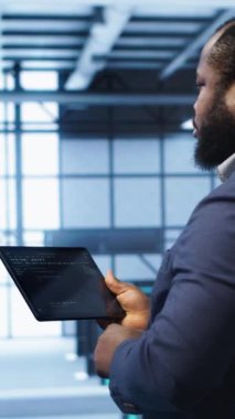 Sunucu odasında, aktarım oranlarını etkileyen ağ sorunlarını düzeltmek için tablet kullanan dikey video bilişim operatörü. Veri merkezinde sunucu sıralarını etkileyen hataları düzelten mühendis, kamera A