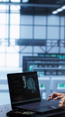 Veri merkezinde dikey video mühendisi yapay zeka hesaplaması kullanarak insan beyninin bilgisayarlı modeldeki düşünme süreçlerini taklit ediyor. Çalışan, yapay zeka öğrenme ile dizüstü bilgisayarda çalışır.