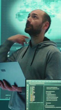 Dikey Video Hükümeti hackerı, bilgisayar ağlarını güvence altına almak için gelişmiş teknolojiyi kullanarak ajans ofisindeki büyük ekranda bilgi inceliyor. Siber güvenlik ve siber savaşa karşı savunma üzerine çalışıyorum.