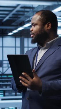 Veri merkezindeki dikey video yazılım mühendisi sorunları çözmek için tablet üzerindeki hata kontrol araçlarını çalıştırır. Bilişim uzmanı, dijital aygıt kullanılarak platformların performansını etkileyen ağ sorunları arıyor