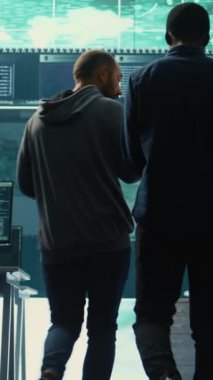 Dikey Video Hükümeti hackerları büyük ekranlardaki siber tehditleri analiz ediyor, yüksek teknoloji bürosundaki önemli veritabanı hackleme faaliyetlerini yönetiyor. Ulusal güvenliği korumak için siber savunma üzerinde çalış