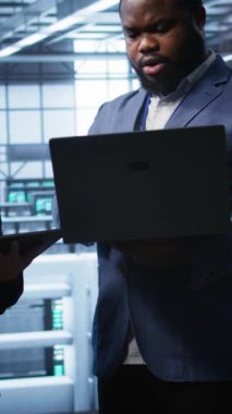 Dikey video çalışanları, veri merkezi ekipman ömrünü uzatmak için tablet ve dizüstü bilgisayar kullanarak yıllık bakım yapıyorlar. Sunucu merkezindeki yönetici ekibi dijital kullanarak süper bilgisayarları izliyor