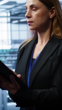 Sunucu odasındaki dikey video yönetimi tablet üzerindeki kurtarma planını kontrol ediyor, ekipman enerji tüketimini izliyor. Bilgi işlem uzmanı veri merkezindeki iş yerlerinde dizüstü bilgisayar kullanıyor, platformların çalışmasını sağlıyor