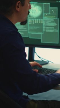 Hükümetin hackleme odasındaki dikey video siber güvenlik uzmanları ağları güvence altına almak için çalışıyorlar. Bilgisayar korsanları kötü amaçlı yazılım tespiti, siber operasyonlar ve dijital paralı askerlere karşı koruma üzerinde yoğunlaşıyor