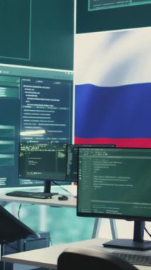 Rus bayrağı ekranda dalgalanırken siber terörizm ve propaganda tehdidi içeren dikey video boş siber savunma odası. Rus hackerların sahte haber yayma faaliyetleri