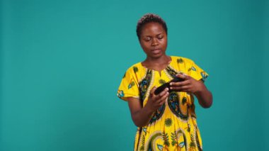 Heyecanlı iyimser kız stüdyoda video oyunlarının zaferini kutluyor, akıllı telefonuyla online mobil oyunlar oynuyor. Mutlu kadın oyuncu siber spor şampiyonluğu kazanıyor. Kamera B.