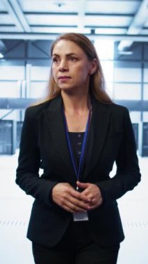 Dikey video yöneticisi sunucu odası ekipmanlarını inceliyor, ana bilgisayarlar arasında yürüyor. Veri merkezi çalışma alanının değerlendirmesini yapan kadın, altyapı kontrolü, izleme performansı, kamera B