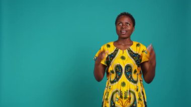 Genç, pozitif bir kadın Tanrı 'ya sağlık ve mutluluk için dua ediyor, dua ediyor ve stüdyoda umutlanıyor. Neşeli iyimser kız iyi hisler ve servet istiyor, yerli etnik kıyafetler. Kamera B.