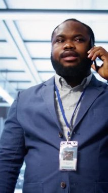 Veri merkezindeki programcının telefon görüşmeleri ve teftiş yaparken çekilmiş dikey görüntüsü. Sahada bilişim uzmanı, telefon görüşmesi sırasında sunucu merkezinde yöneticiyle konuşuyor.