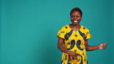 Tatlı oyuncu kadın ritmi korumak için parmaklarını şıklatıyor, stüdyoda dans ediyor ve hareket ediyor. Geleneksel yerli kıyafetleri içinde hoş bir kız. Havalı ve havalı davranıyor. Dans hareketleri yapıyor. Kamera B.