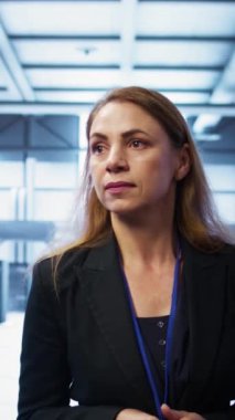 Dikey video yöneticisi sunucu odası ekipmanlarını denetliyor, süper bilgisayarlar arasında yürüyor. Veri merkezi konumu değerlendirmesi yapan denetleyici, ekipman kontrolü, izleme performansı, kamera B