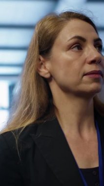 Dikey video yöneticisi sunucu odası ekipmanlarını denetliyor, süper bilgisayarlar arasında yürüyor. Veri merkezi konumu değerlendirmesi yapan denetleyici, ekipman kontrolü, izleme performansı, kamera A