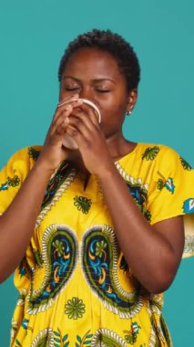 Geleneksel etnik kıyafetli dikey Video Kadını kahve fincanından bir yudum içerek harika kavrulmuş aromalı taze kafein içeceği servis ediyor. Mutlu kız stüdyoda içecek bir şeyler içiyor.