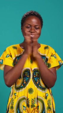 Dikey Videolu Neşeli Genç Kadın bir şeyden memnun ve memnun hissediyor, ellerini çırpıyor ve iyimser duygular gösteriyor. Geleneksel etnik kıyafetleri olan mutlu bir insan.