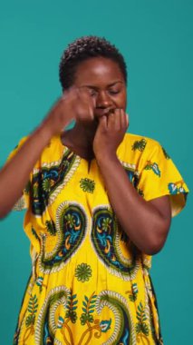 Dikey Videolu Sinirli Kadın bir şeyden endişeleniyor ve stres ve hayal kırıklığından dolayı tırnaklarını yiyor. Endişeli genç kız paniklemiş hissediyor, çiçekli elbise giyiyor.