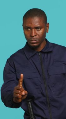 Güvenlik görevlisinin parmak hareketi yapmadan dikey görüntü portresi, mülkü denetlerken girişi yasaklıyor. İnsanların stüdyoya girmesini yasaklayan özel kanun adamı.