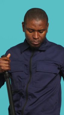 Güvenlik görevlisinin dikey güvenlik kamerası görüntüsü, el fenerini açmak ve şüphelileri tutuklamak için cop hazırlamak. Fener ve copla çalışan özel bir polis memuru, stüdyo.