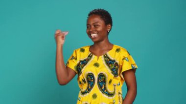 Tatlı oyuncu kadın ritmi korumak için parmaklarını şıklatıyor, stüdyoda dans ediyor ve hareket ediyor. Geleneksel yerli kıyafetleri içinde hoş bir kız. Havalı ve havalı davranıyor. Dans hareketleri yapıyor. Kamera A.