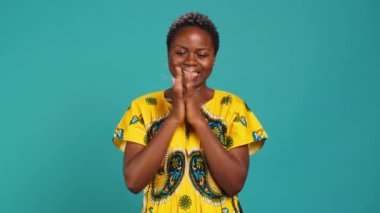 Neşeli genç bir kadın bir şeyden memnun ve memnun hissediyor ellerini çırpıyor ve iyimser duygular gösteriyor. Geleneksel etnik kıyafetleri olan mutlu bir insan. Kamera A.