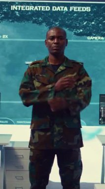 Görev kontrol merkezinde kamuflaj üniforması giyen kendine güvenen askeri generalin dikey video portresi ulusal güvenlik ve protokolle ilgili operasyonları denetliyor. Federal Ordu Üssü Komutanlığı