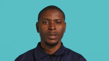 Siyahi stüdyo geçmişiyle izole edilmiş Afrikalı Amerikan güvenlik ajanının portresi. Gardiyanın, stüdyo arkaplanının başında dikilirken yakın plan çekimi, kamera A