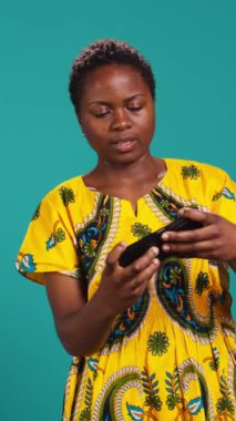 Dikey Video Heyecanlı iyimser kız video oyunlarındaki zaferini stüdyoda kutluyor, akıllı telefonuyla online mobil oyunlar oynuyor. Mutlu kadın oyuncu siber spor şampiyonluğu kazanıyor. Kamera B.