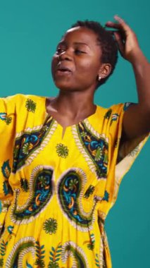 Dikey Video Kadın Modeli Stüdyoda heyecanlı ve mutlu, özgüvenle fotoğraf çekiyor ve akıllı telefonuyla iyi titreşimler alıyor. Portreler için kendini fotoğraflayan genç bir kadın. Kamera.