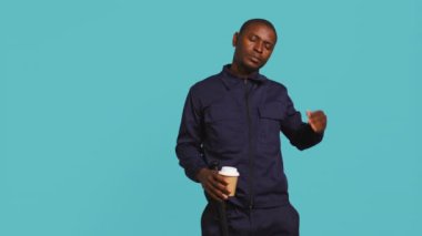 Uyanık kalmak için kahve fincanı içen yorgun güvenlik görevlisi, suçluları önlemekle görevlendirildi. Gece vardiyasında kafeinli içecek yudumlayan yorgun korumaların portresi, stüdyo arka planı, kamera B