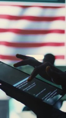 Amerikan bayrağıyla birlikte devletin bilişim alanında dikey video güvenlik uzmanı. Siber tehditlere karşı korunmak için bir tablette siber güvenlik, şifreleme ve veri güvenliğinin izlenmesi. Kapat