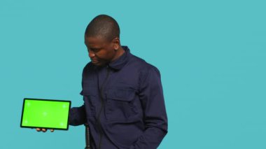 Krom anahtar tableti sunan güvenlik ajanının portresi ve atama görevi, stüdyo geçmişi. Gardiyan, güvenlik ihlalleri ile uğraşırken izole ekran cihazını işaret ediyor. Kamera A