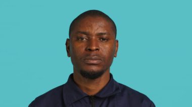 İş yerindeki güvenlik görevlisinin gülümseyen ve etrafı gözetleyen portresi. Neşeli özel güvenlik görevlileri iş yaparken sırıtıyorlar, yakın çekim, stüdyo arkaplanı, kamera A