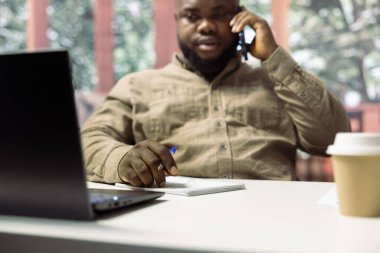 Yönetici, genişleme ve geliştirme fonlarını arttırmak için hissedarlarla telefonda görüşüyor. Evden çalışan ve yatırımcıları yıllık raporlarını paylaşmaya çağıran adam.