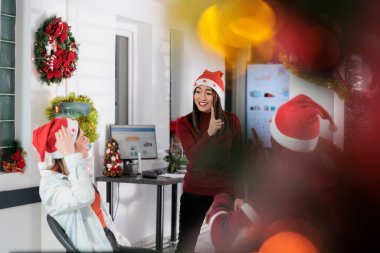 Multiethnic business team at social gathering in festive decorated office during coffee break, enjoying time together. Group of close knit coworkers having fun during Christmas holiday season clipart