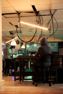 Phishing saldırısı, internet dolandırıcılığı programı kodlaması, bilgisayardaki şifre kırma uygulaması. Siber saldırı, veri sızıntısı, gece vakti kötü niyetli yazılım geliştiren kapüşonlu kadın.
