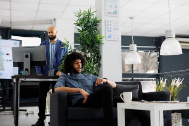 Şok olmuş Arap işadamı mesai saatlerini kontrol ediyor ve çalışma alanında koltukta otururken iş toplantısını bekliyor. Kol saatine bakarak şirket yöneticisini başlat