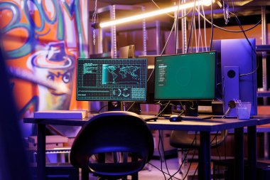 Gece vakti terk edilmiş depoda bilgisayar ekranı hackleme sunucusunda kötü niyetli yazılım. Fidye virüsü bilgi çalıyor ve hackerların saklandığı yerdeki monitörden veritabanına sızıyor.
