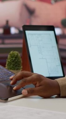 Dikey Video Profesyoneli girişimcisi planları inceliyor ve ofis alanı planlama ve geliştirme için dijital araçlar kullanıyor. Kiralama ve yatırım stratejisi için işletme sahibi çalışma alanı tasarımı