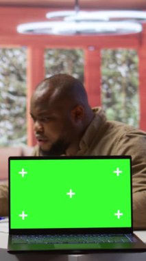 Dikey Video Genç girişimcisi, bir tablet üzerinde taklit uzay görüntüsü kullanarak, ev masasında bütçe dengesi raporlarını gözden geçiriyor. İşadamı yeni yatırım fonları elde etmek için aylık satışları gözden geçirdi