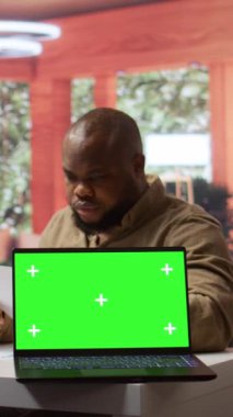 Vertical Video Startup yöneticisi, izole edilmiş yeşil ekran kullanarak ev ofisindeki ekonomik bütçe dengesini hesaplar. Girişimci aylık satış raporlarını, yatırım fonlarını gözden geçiriyor. Kamera.