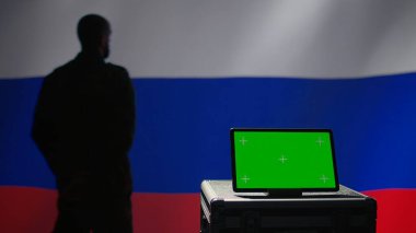 ex KGB FSB secret police agent using mass propaganda tools on green screen laptop to influence population minds. Russian spy silencing online opposition voices using mockup notebook, camera B clipart