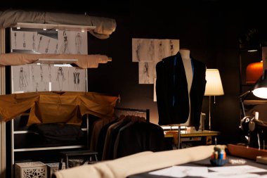 Kaliteli kaliteli, zarif giysi ve duvarlarda moda tasarımı çizimleriyle dolu lüks bir atölye. Mankenler üzerine süslü giysileri olan terzi stüdyosu.